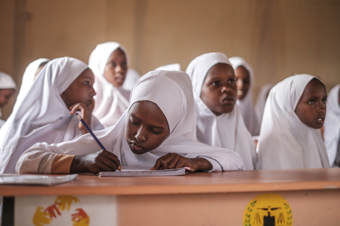 Students in a Somaliland classroom, with a learner writing in her notebook